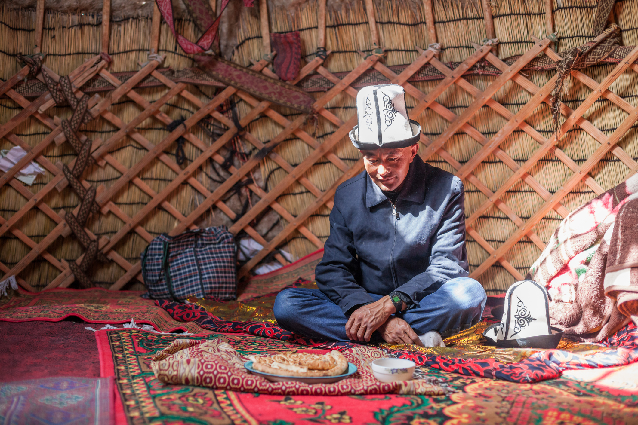 Adult kyrgyz man drinking tea inside a yurt, Xinjiang, China