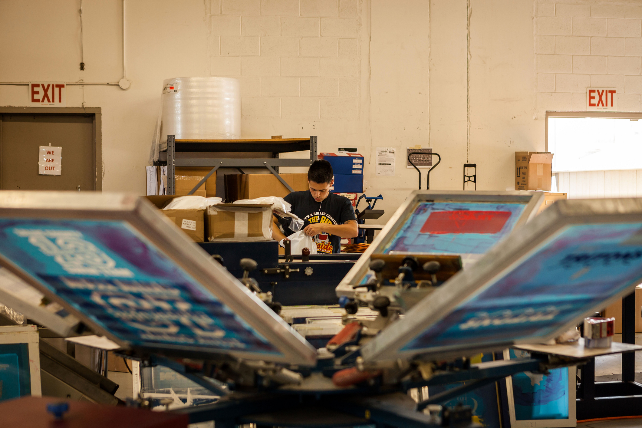 A man operating screen printing equipment
