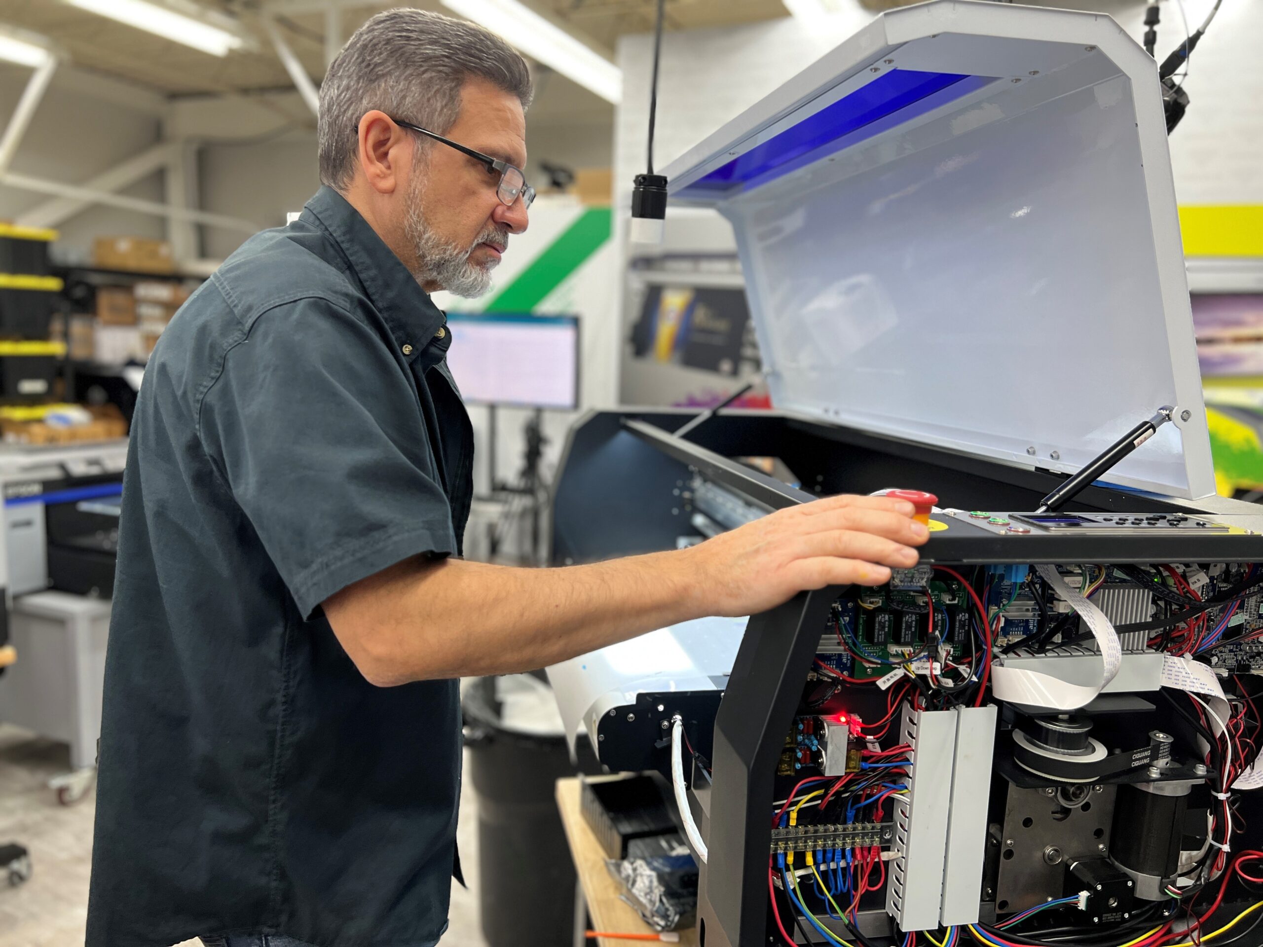 A man performs maintenance tasks on a printer