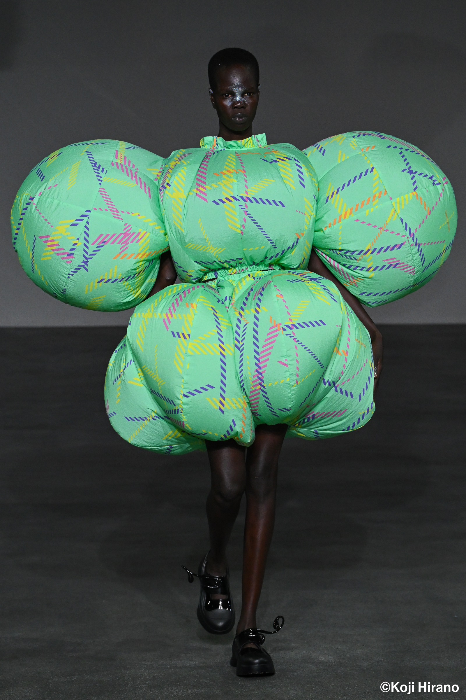 woman wearing puffy teal dress walking down a runaway