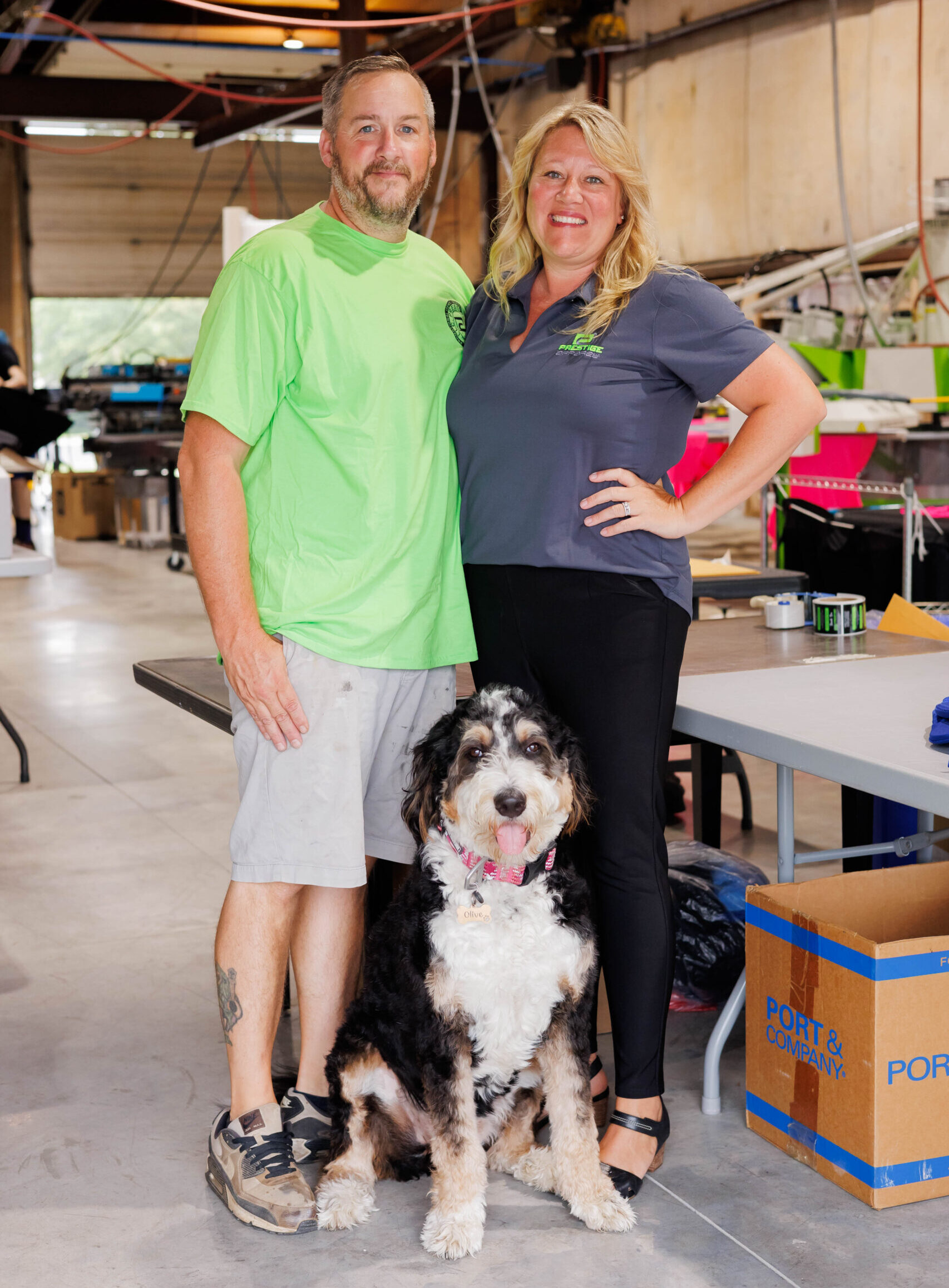 Prestige Apparel Owners Ryan and Jess Miller with shop dog Olive. 