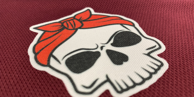 A close-up of a heat transfer patch in the shape of a skull wearing a bandanna