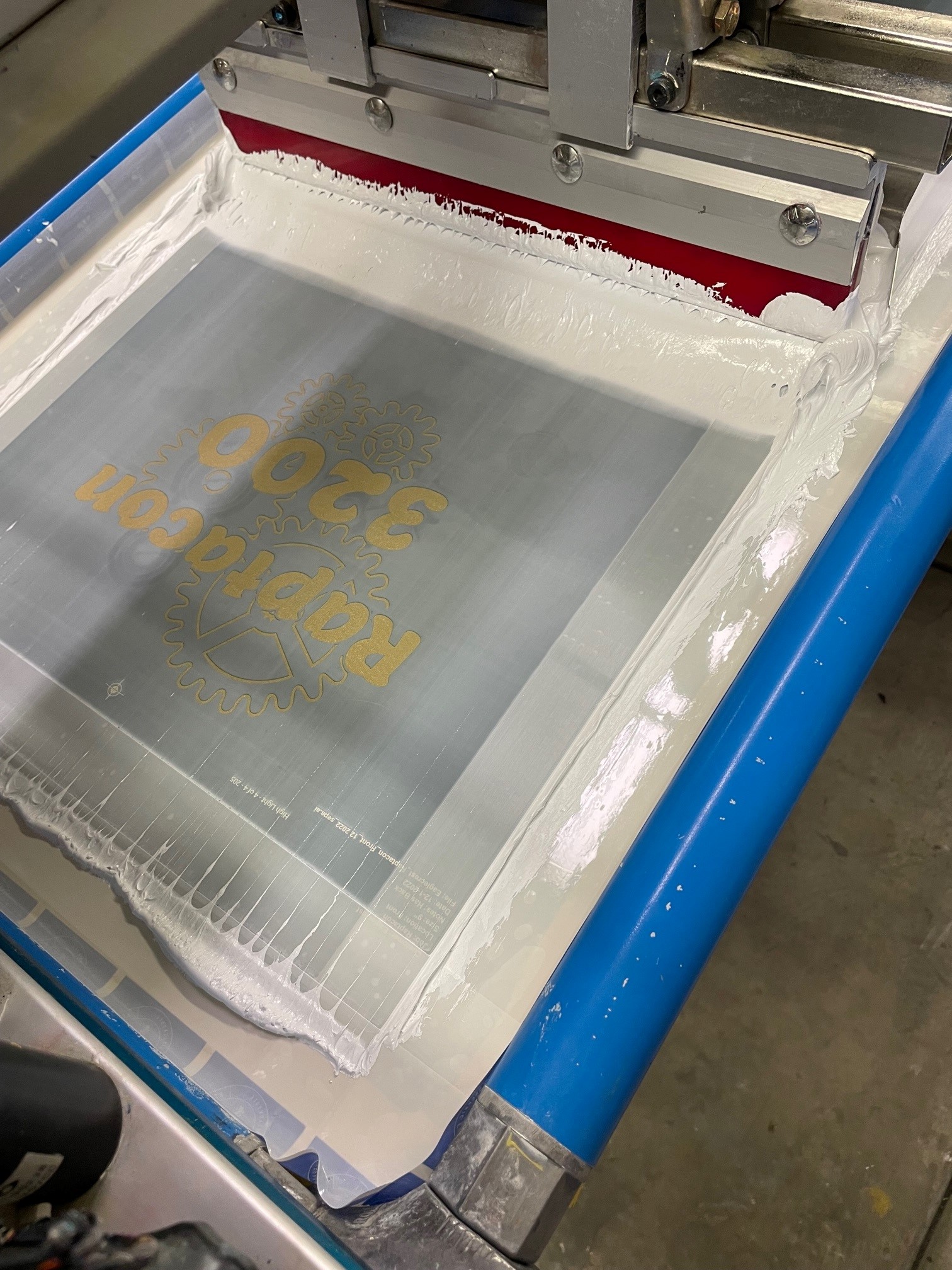 A screen with white ink and a Raptscon design