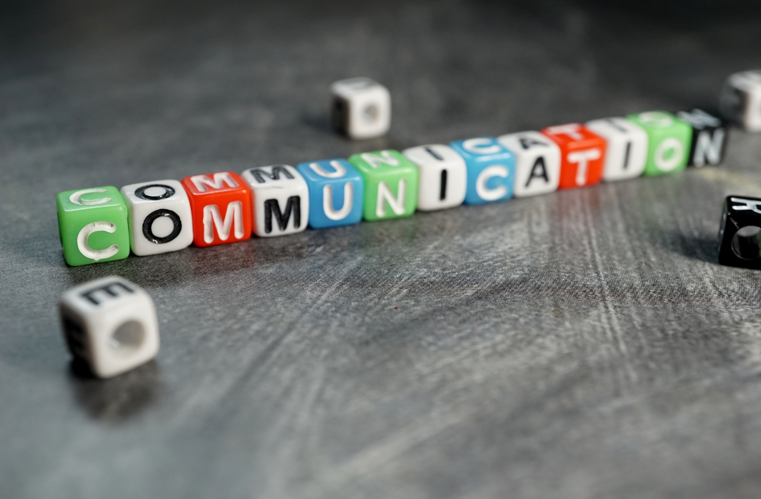 The word Communication spelled out using colorful block beads