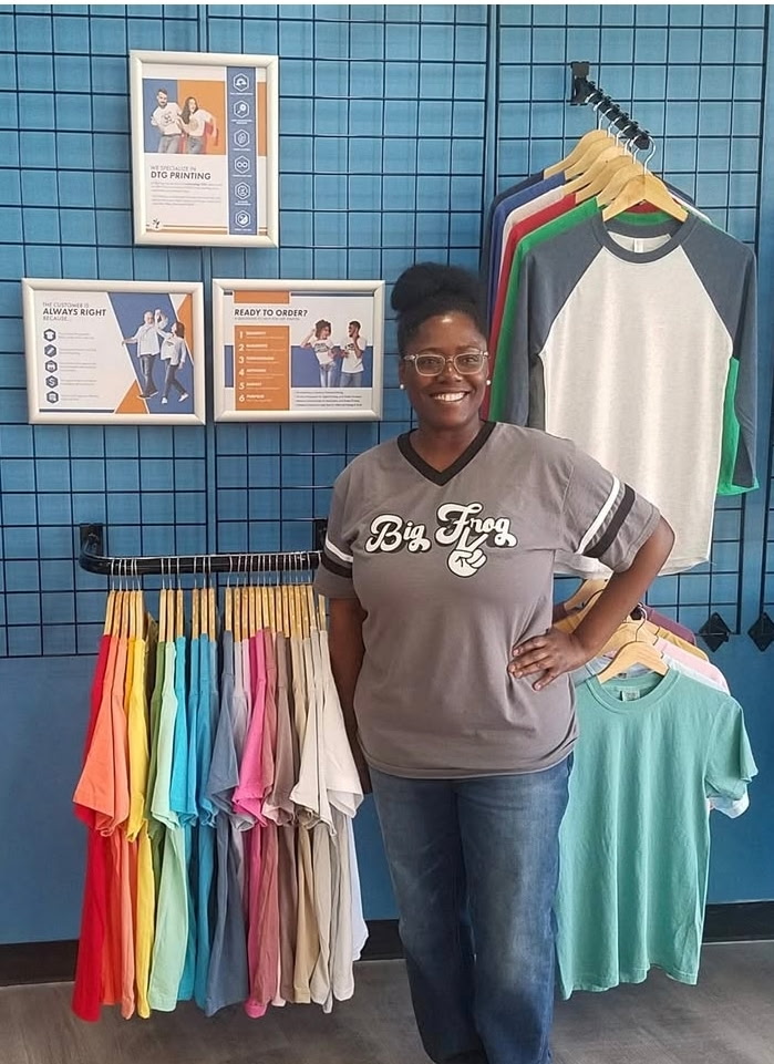 Domonique Downing standing in front of a rack of T-shirts