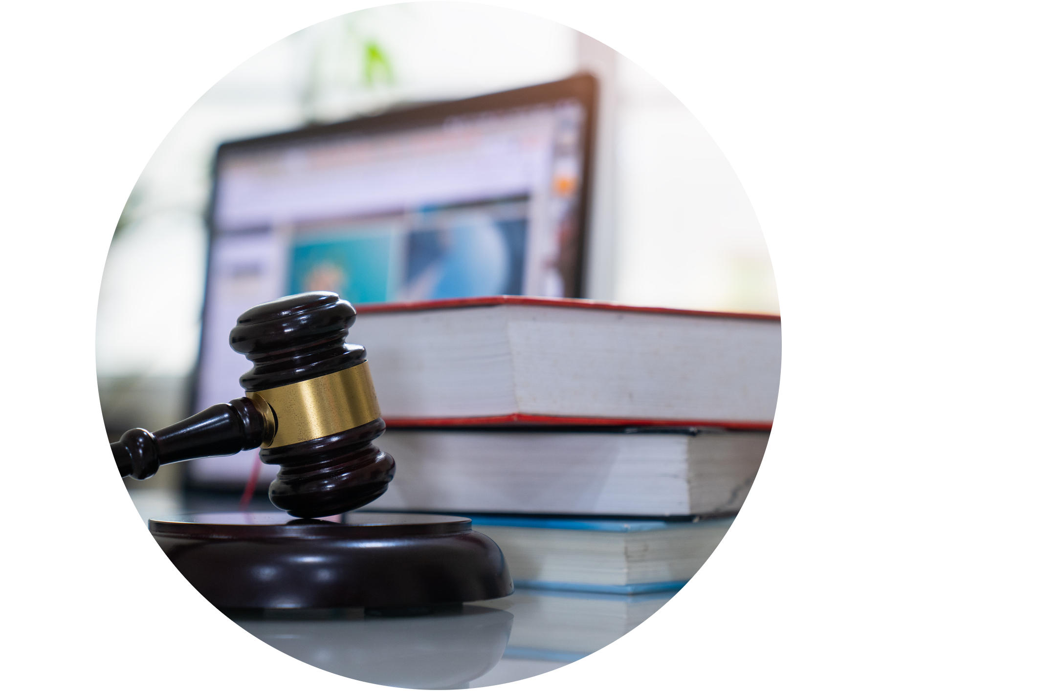 A gavel with a laptop and books in the background