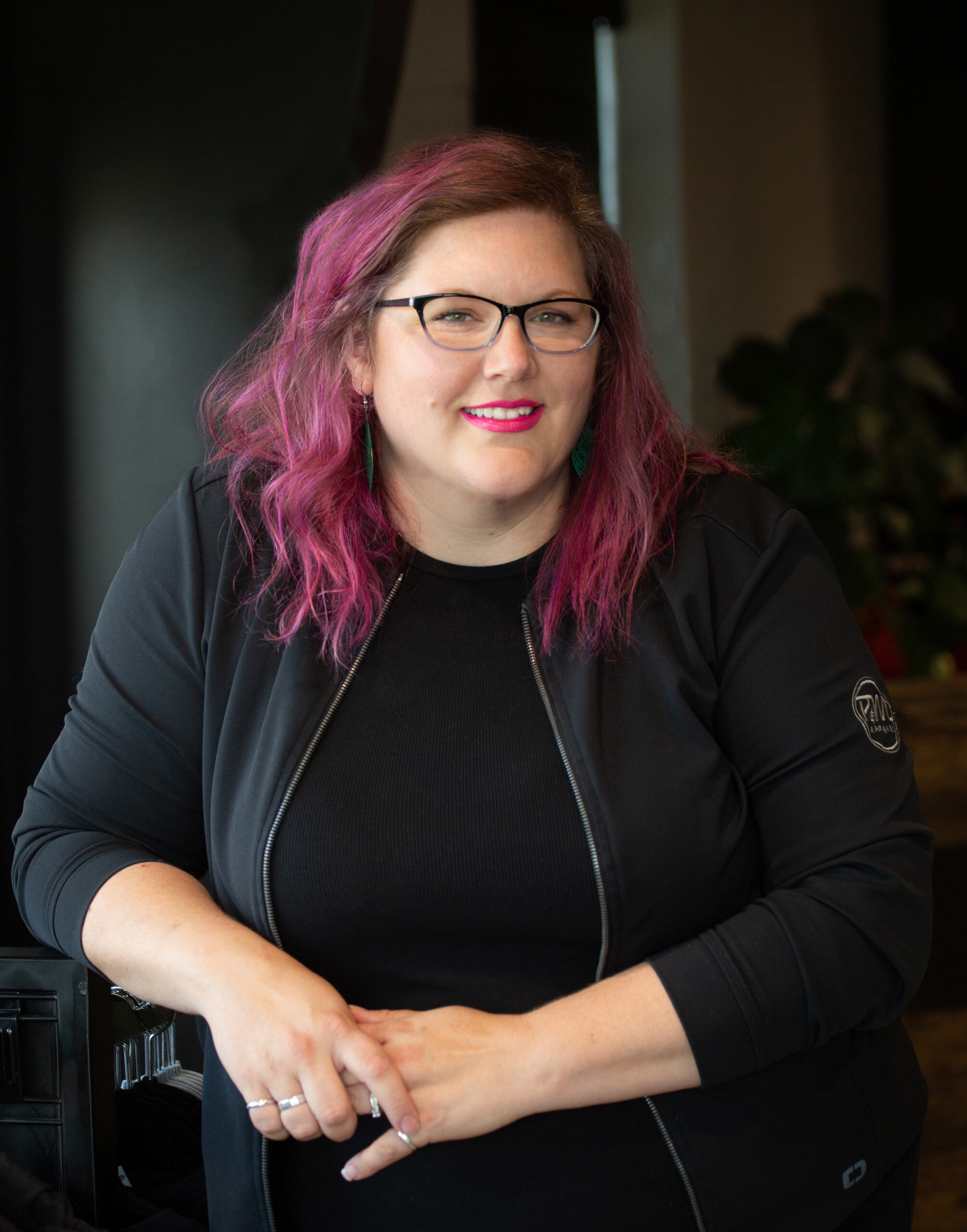 Megan Griffith with pink hair wearing black outfit