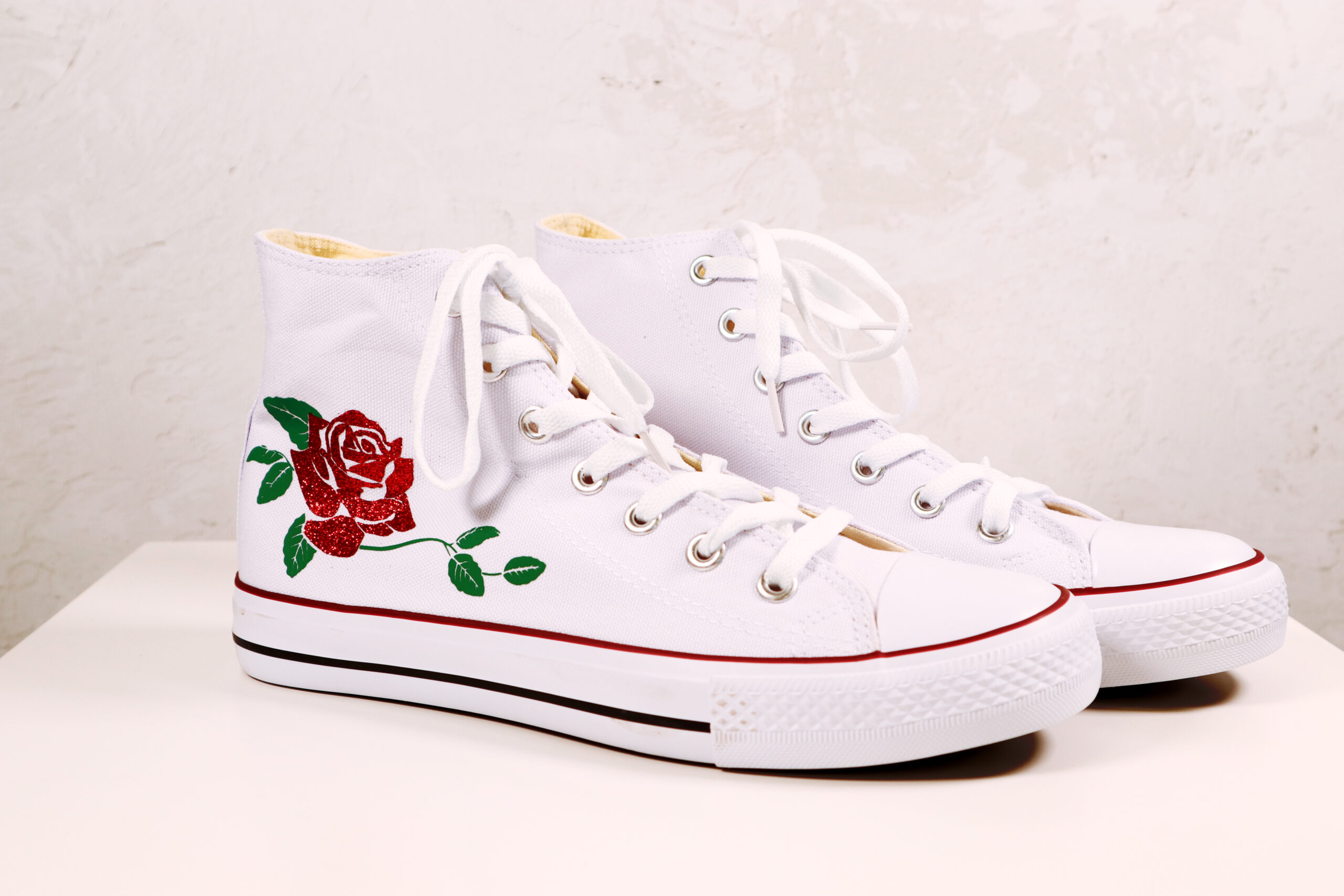 White canvas shoes decorated with red glitter rose