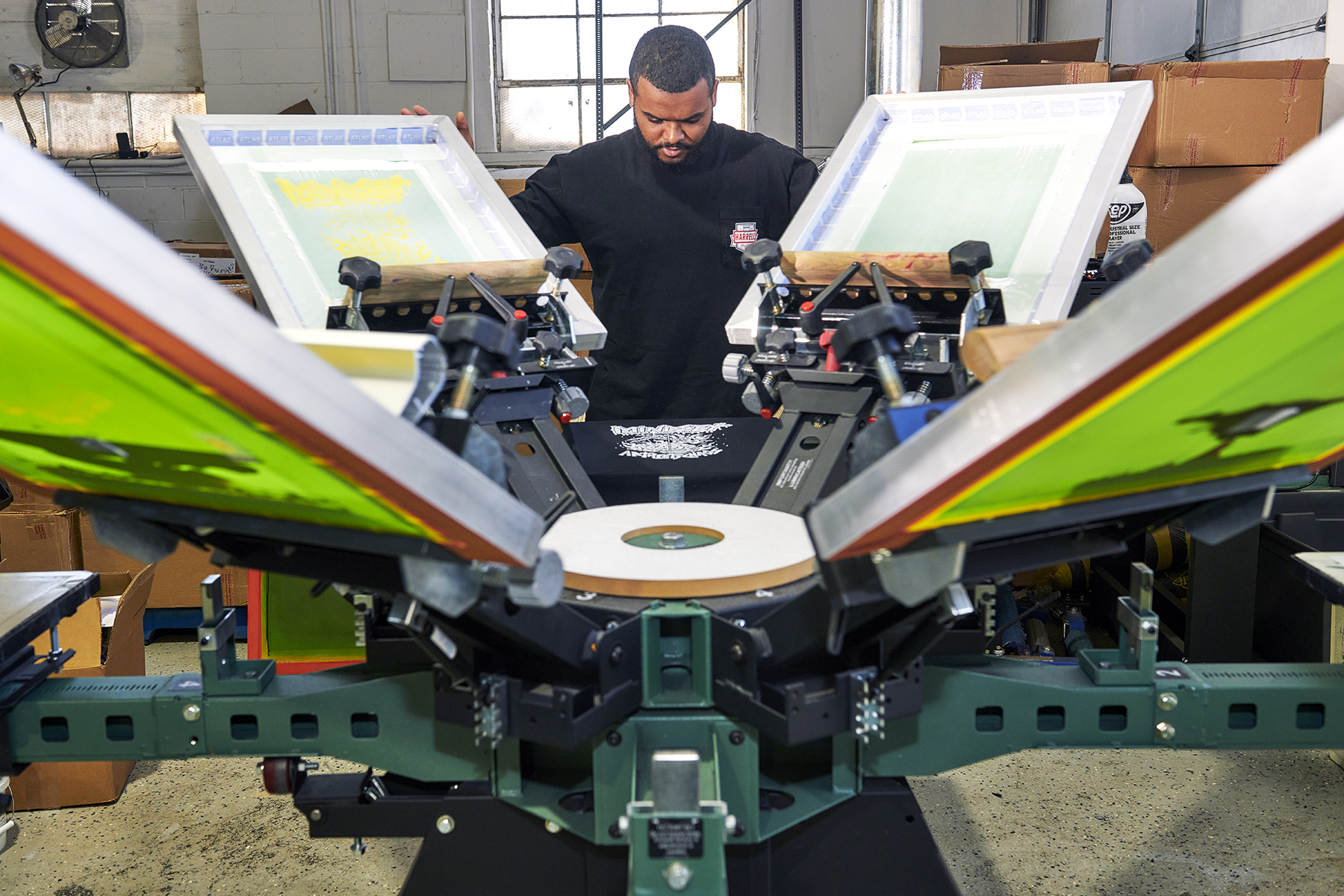 A view of Joaquin standing in between screens on press