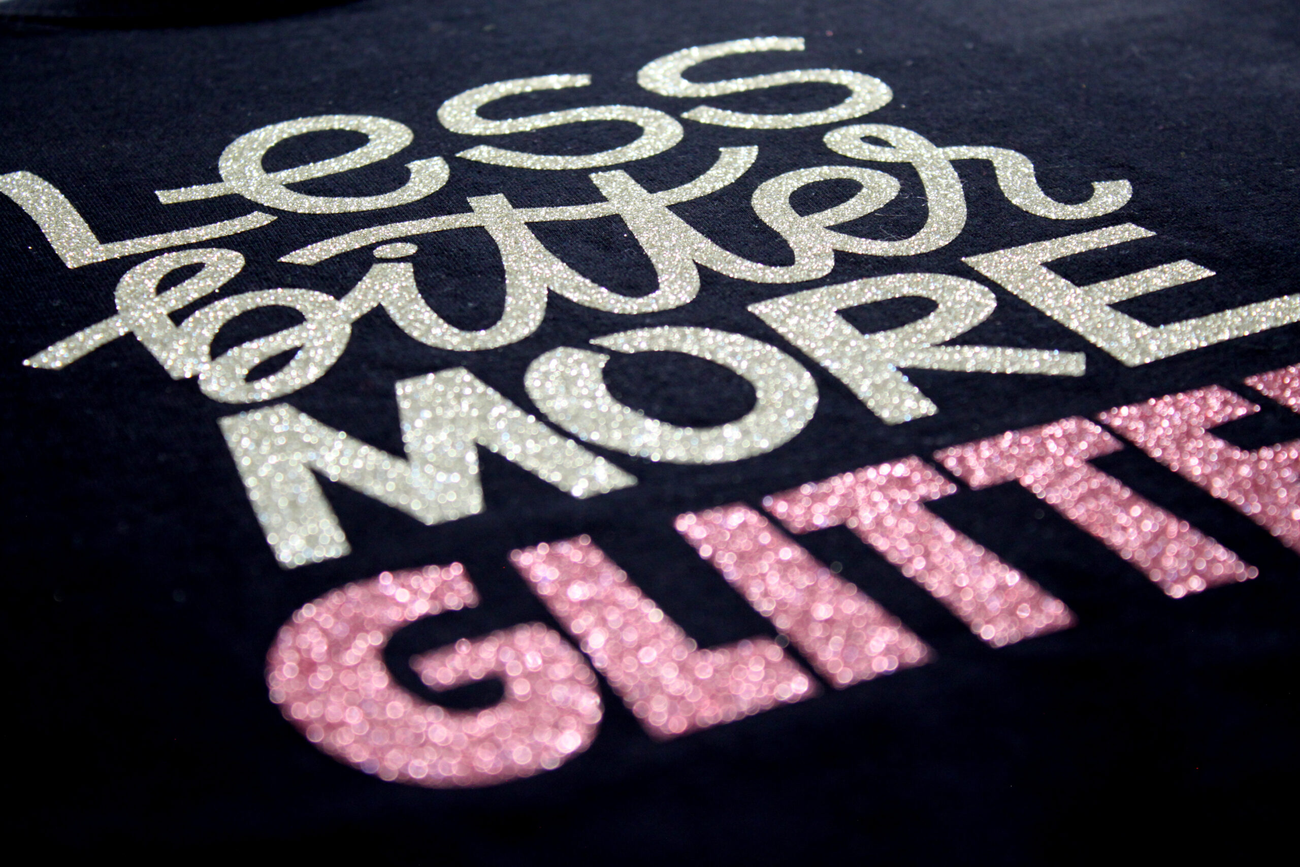 A black garment decorated with white and pink glitter letters