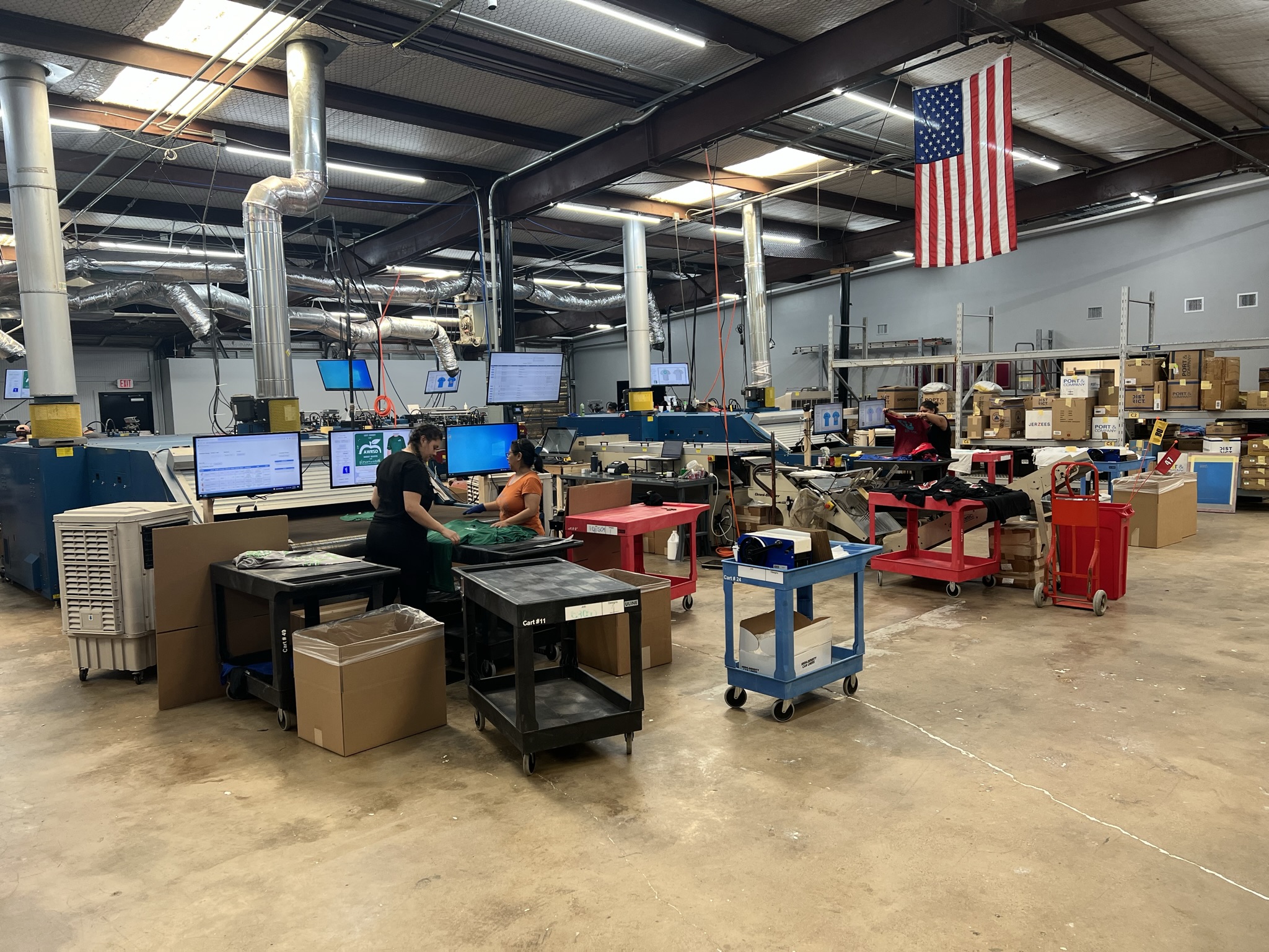 Employees screen printing shirts at hightech Grafix