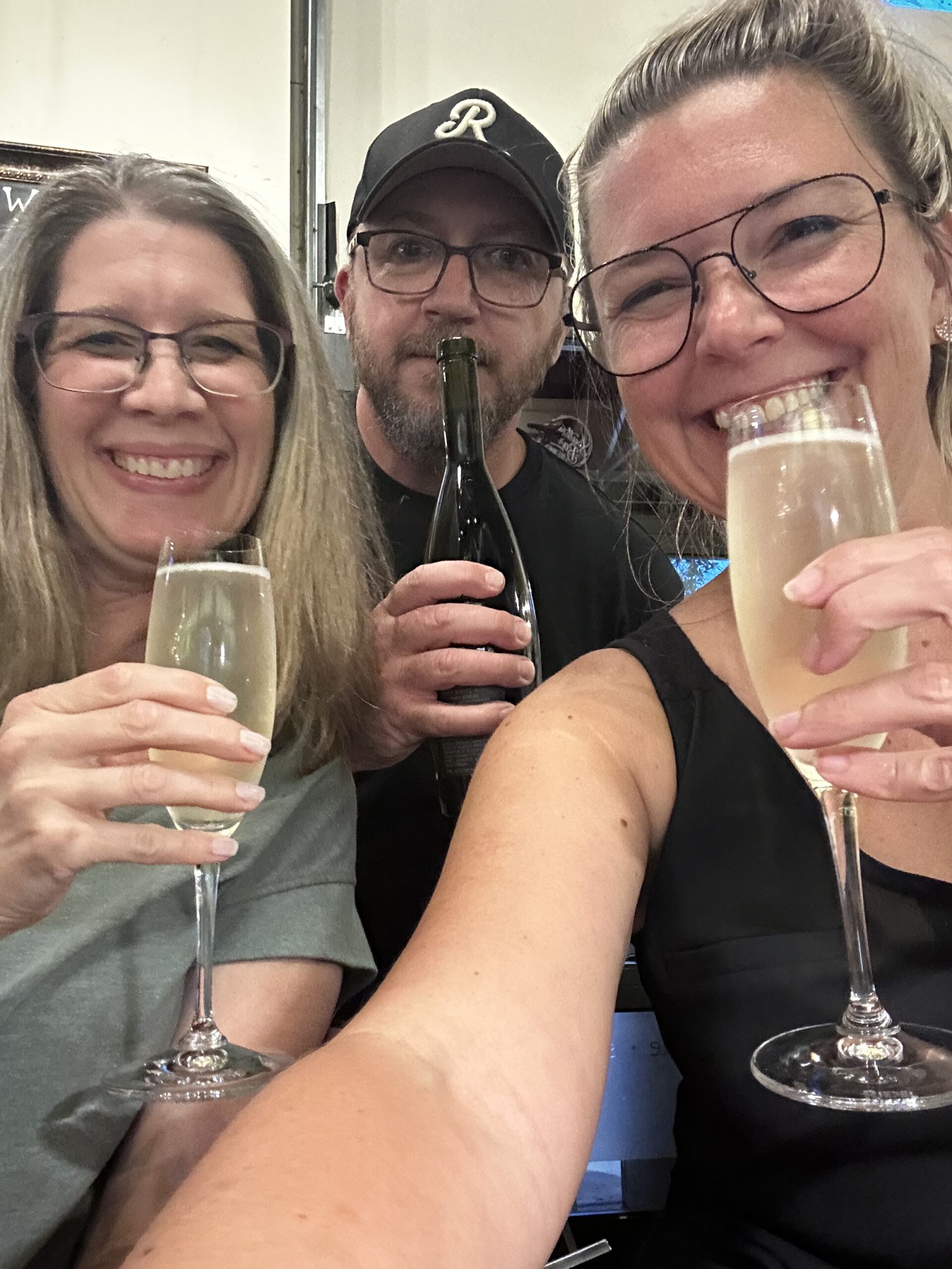 Left to right is Jill Ray, Jeremy Ray, and Christy Shellenberger holding glasses of wine