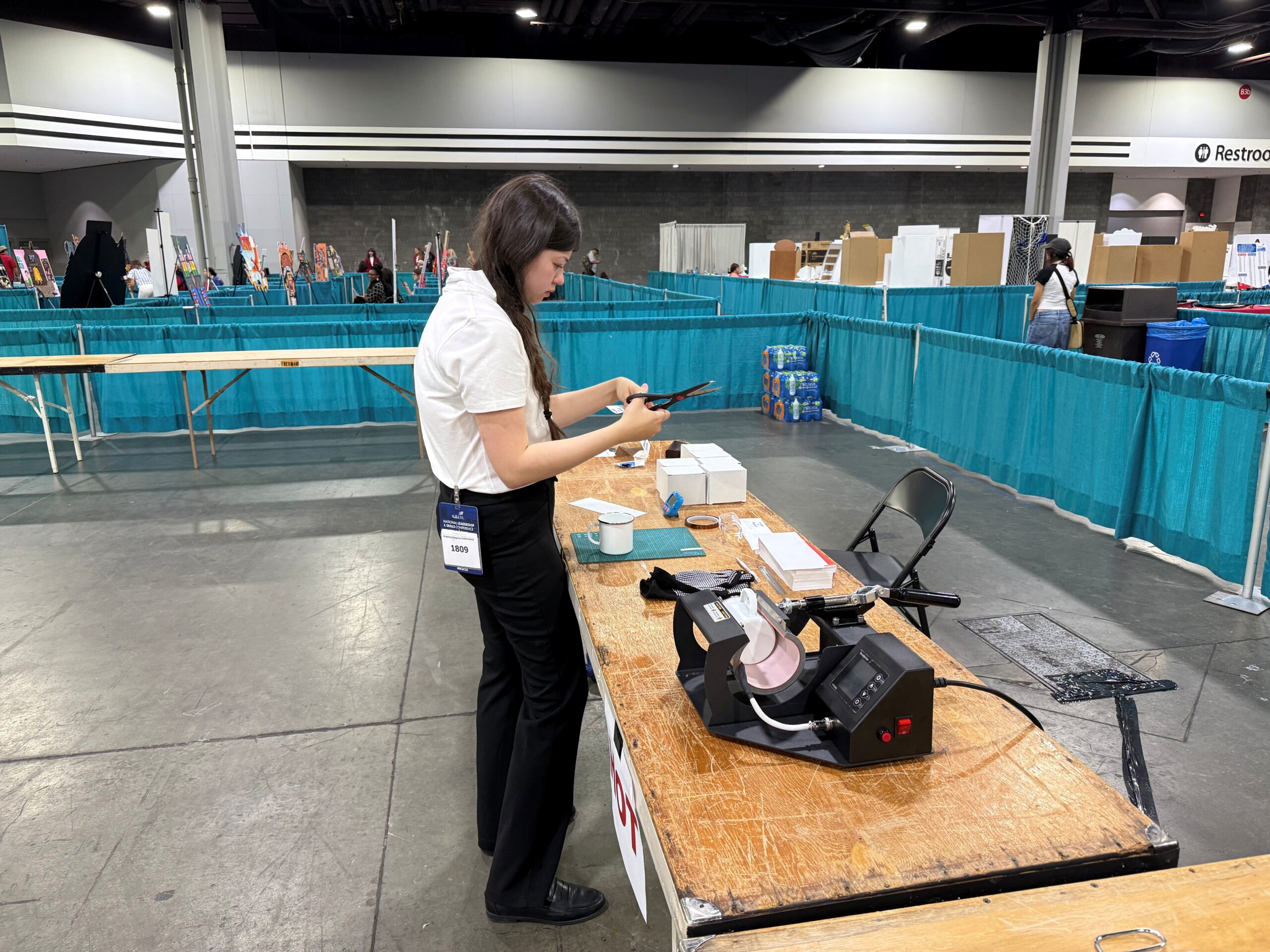 A girl cuts a transfer during the sublimation portion of the competition