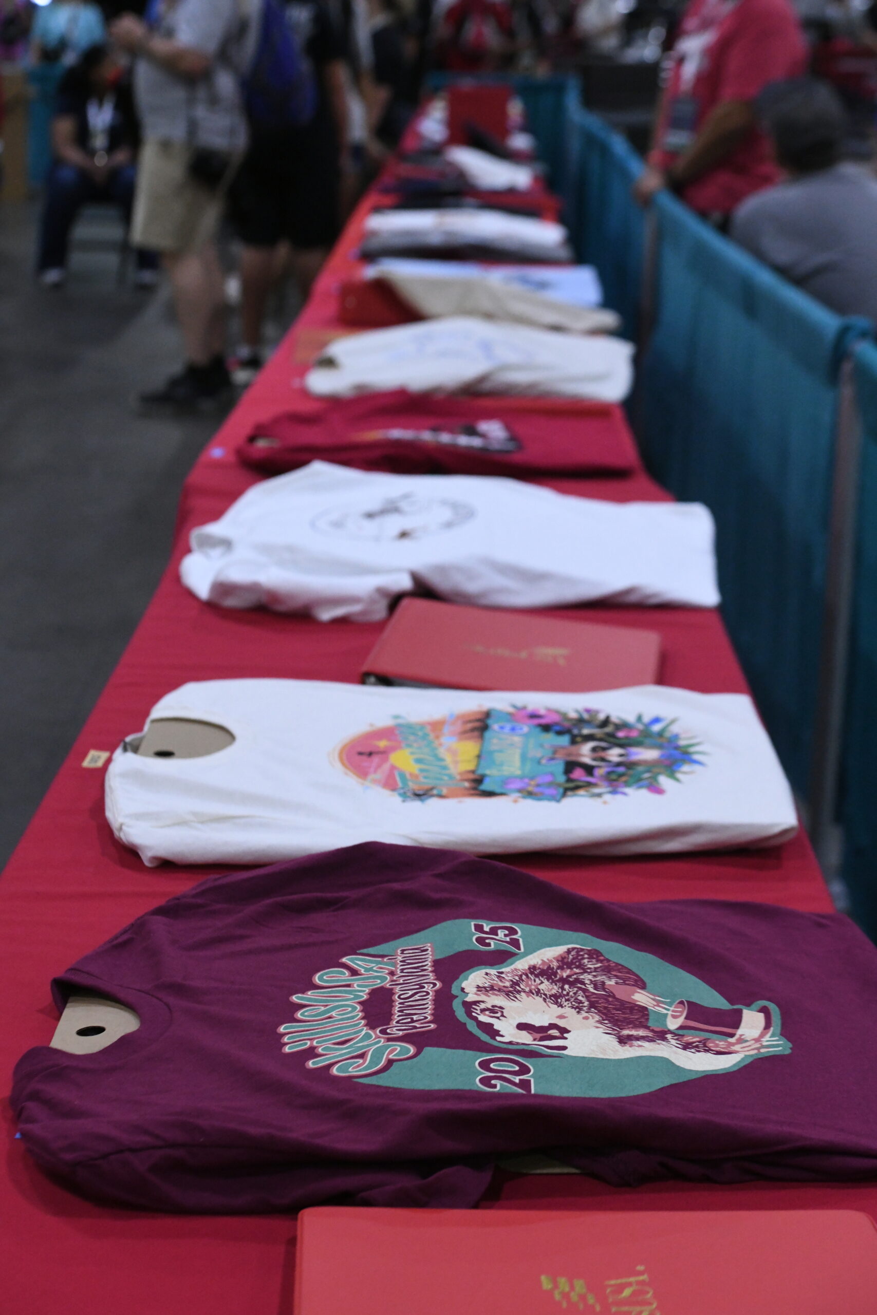 T-shirts laying on a table with a red table cloth