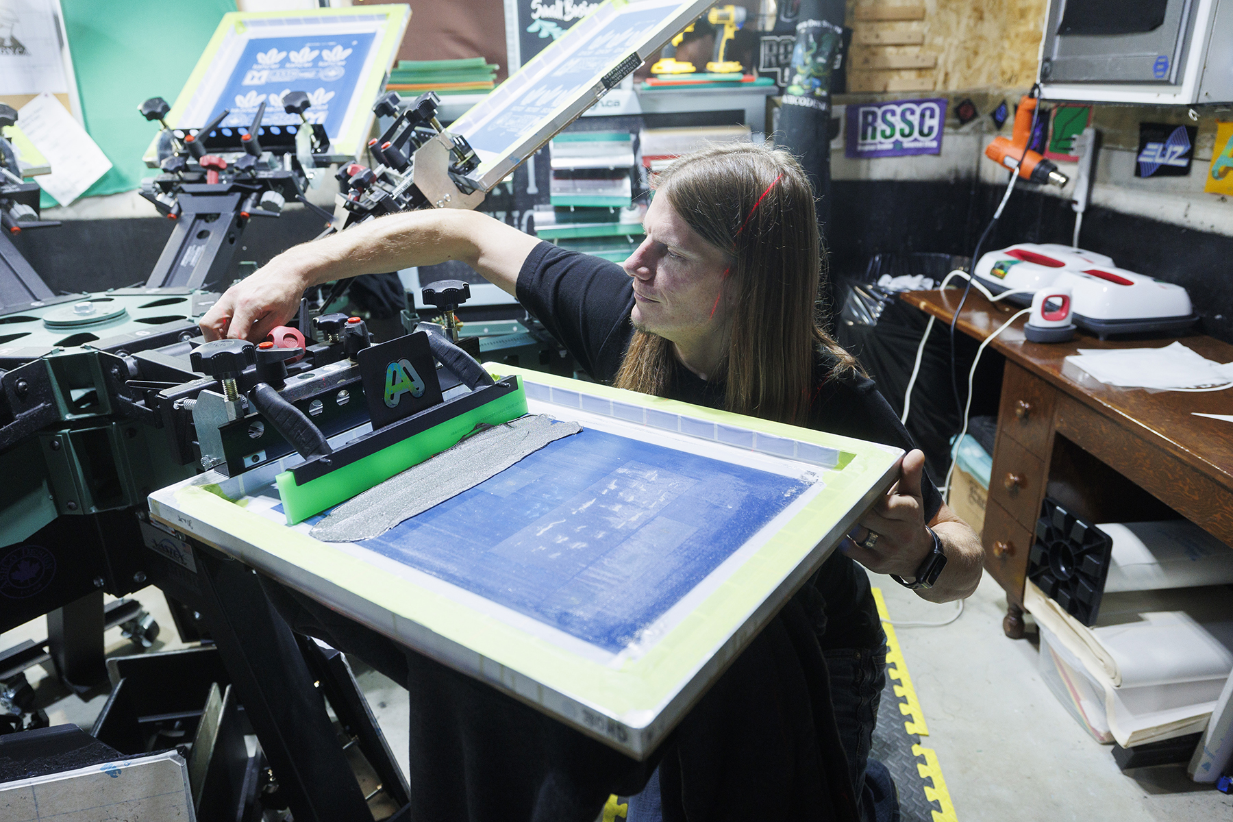 Moulds levels the screen onto the pallet before applying the first layer of ink.