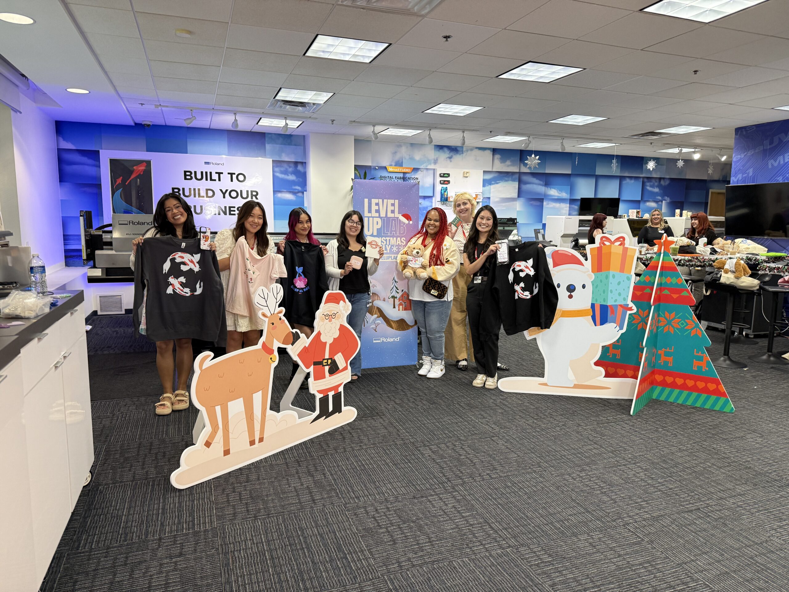 Six attendees of the Roland DGA Christmas in July event hold their printed products