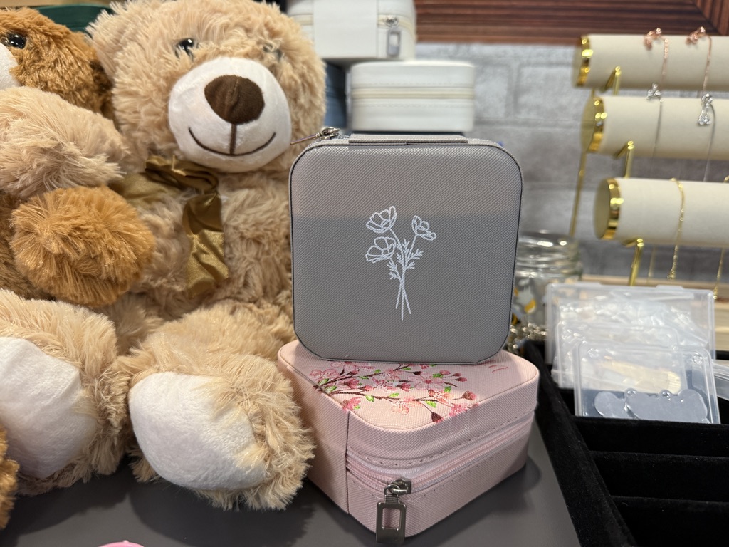 Stuffed teddy bears sitting next to printed jewelry boxes