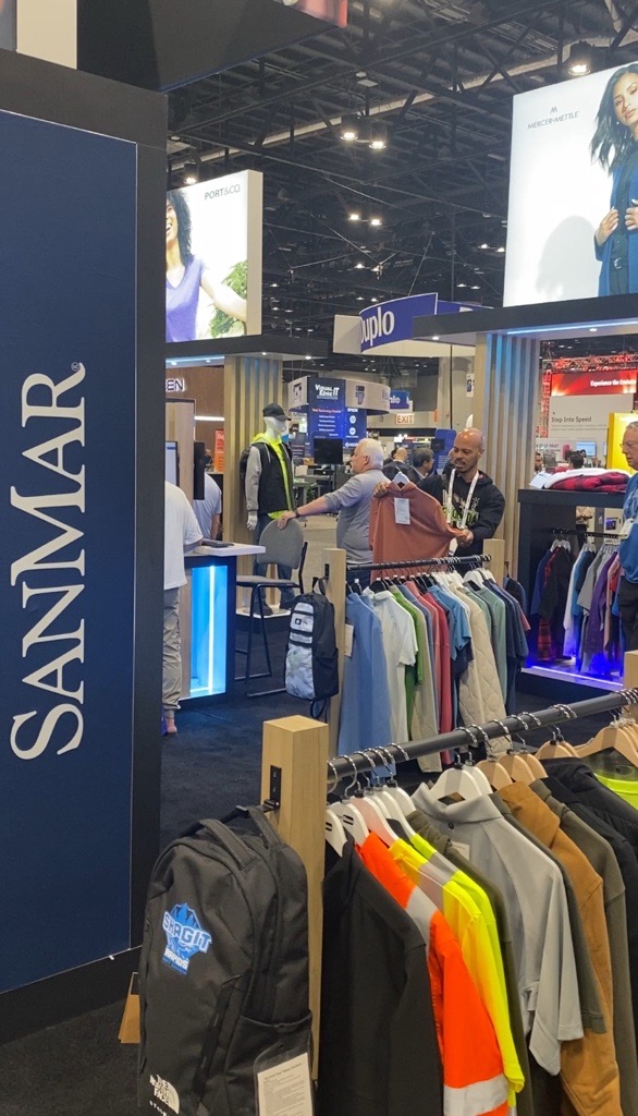 A wide angle image of apparel blanks with the SanMar logo on the left