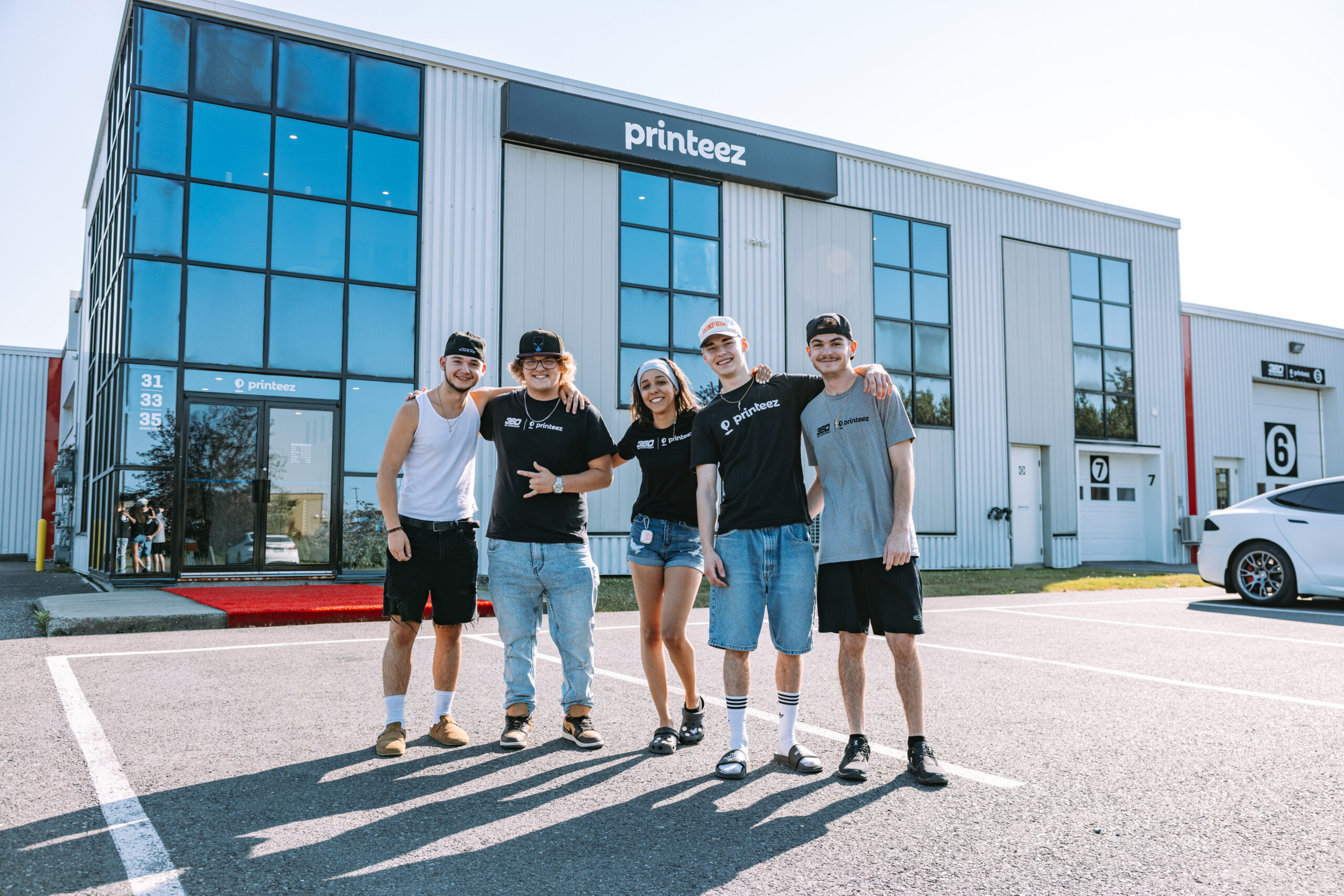 five people stand in front of the Printeez white building