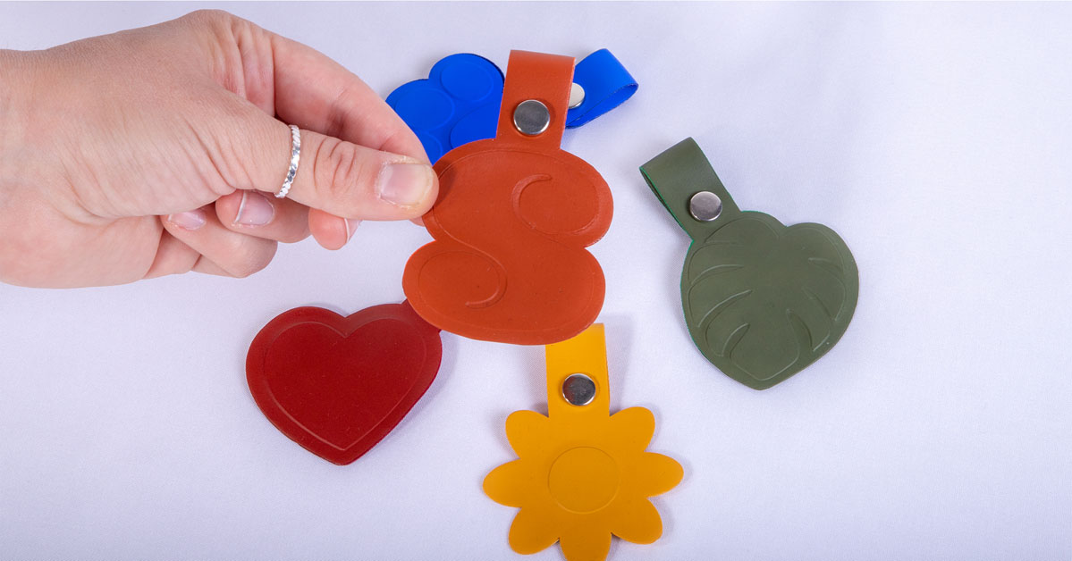 person holding keychain with colorful keychains in background
