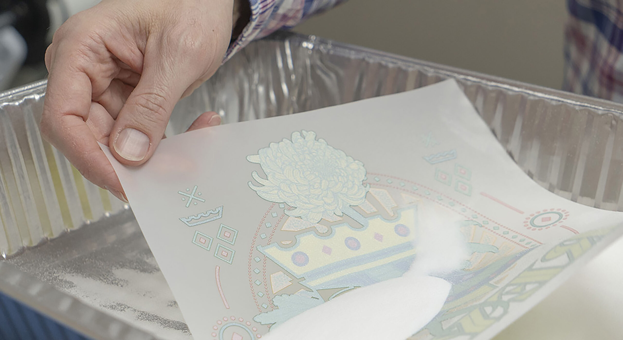person holding DTF transfer in powder