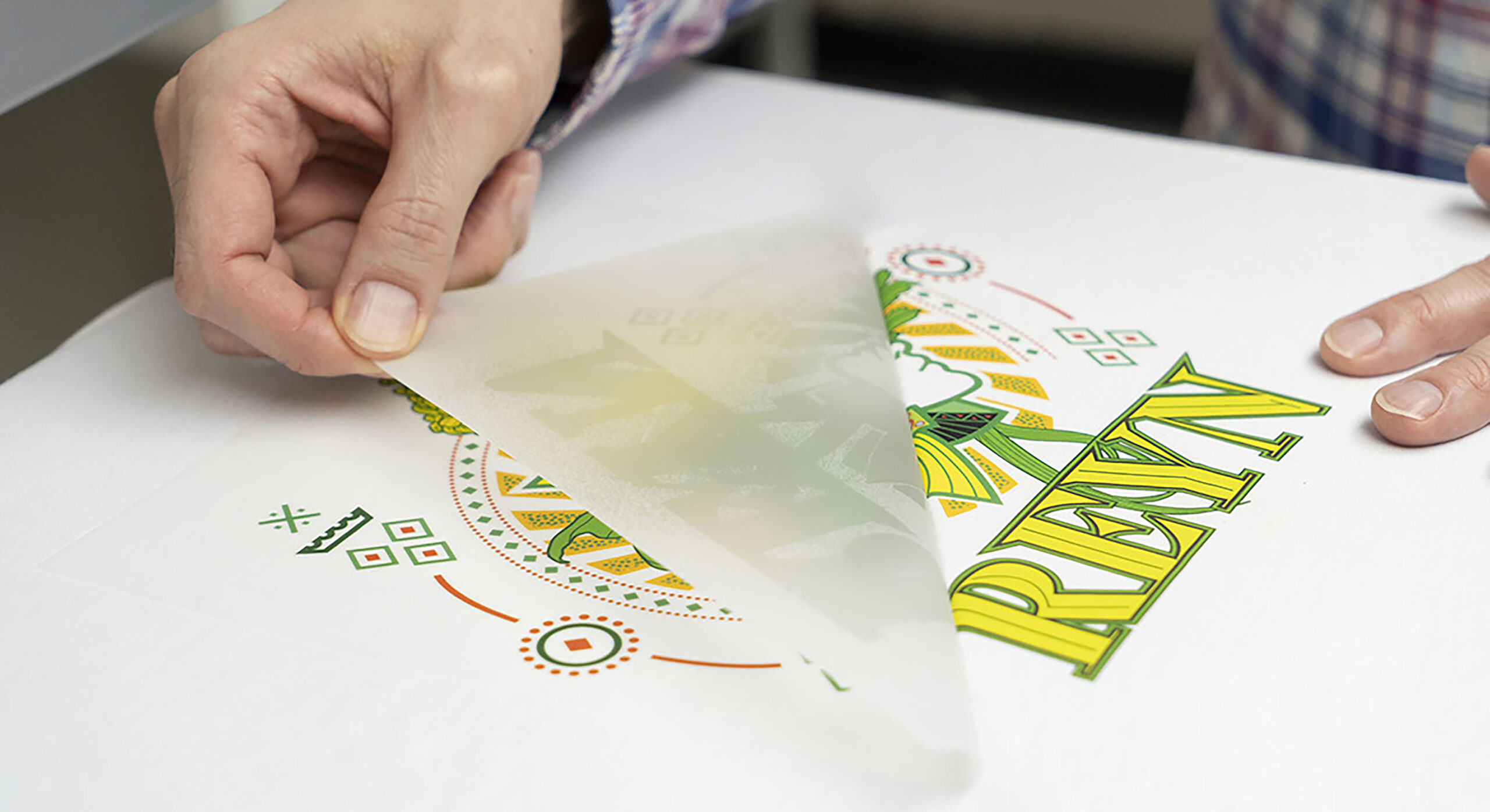 hand peeling a transfer off a white shirt
