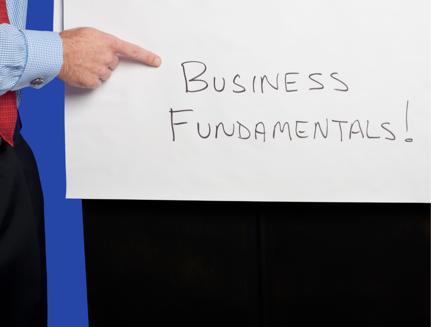finger pointing to words Business Fundamentals on chalkboard