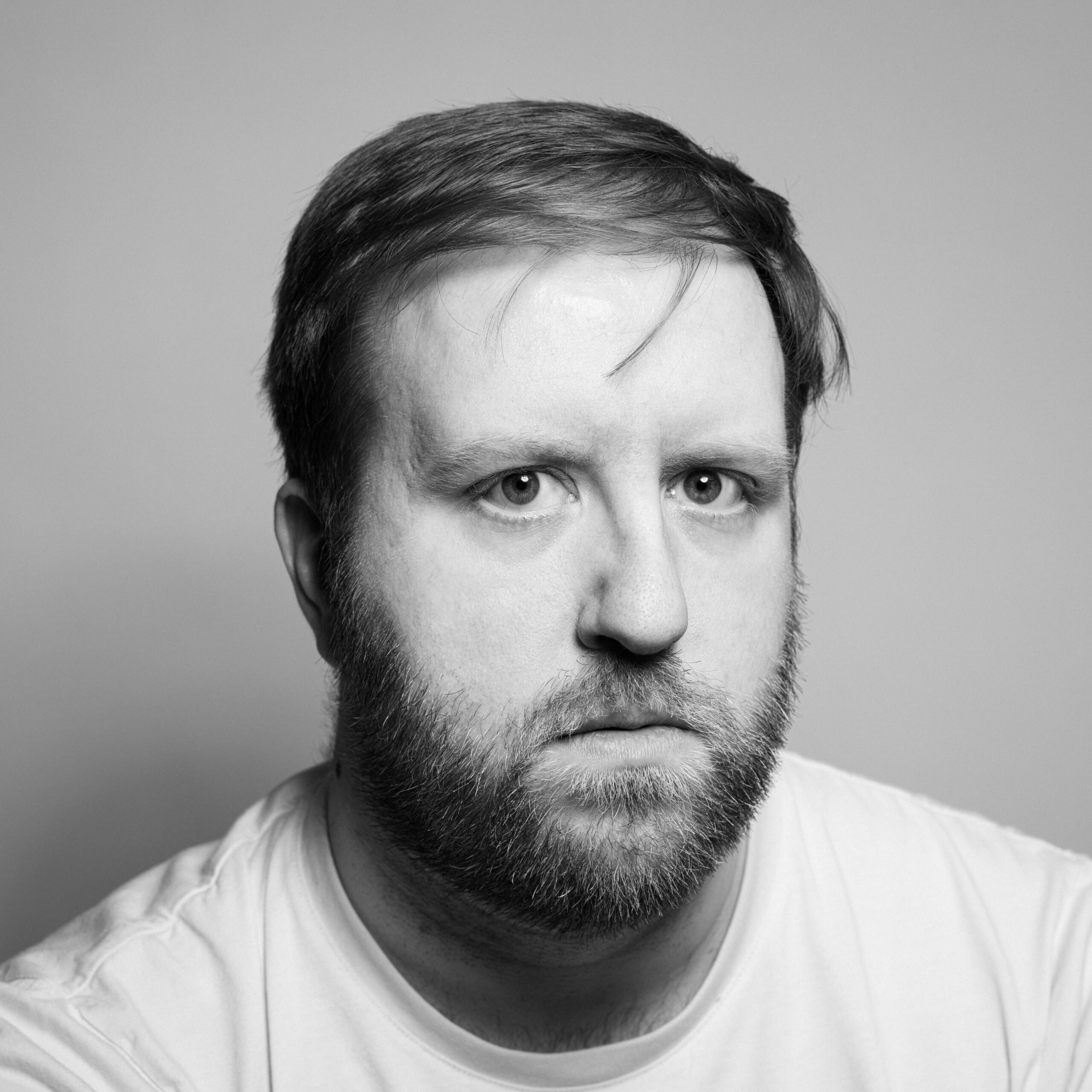 black and white headshot of man in white tshirt