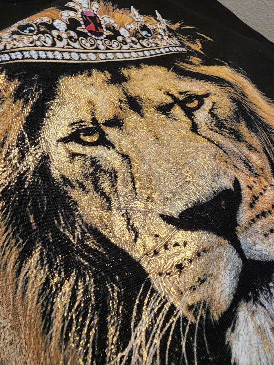 close-up of metallic lion print on black shirt