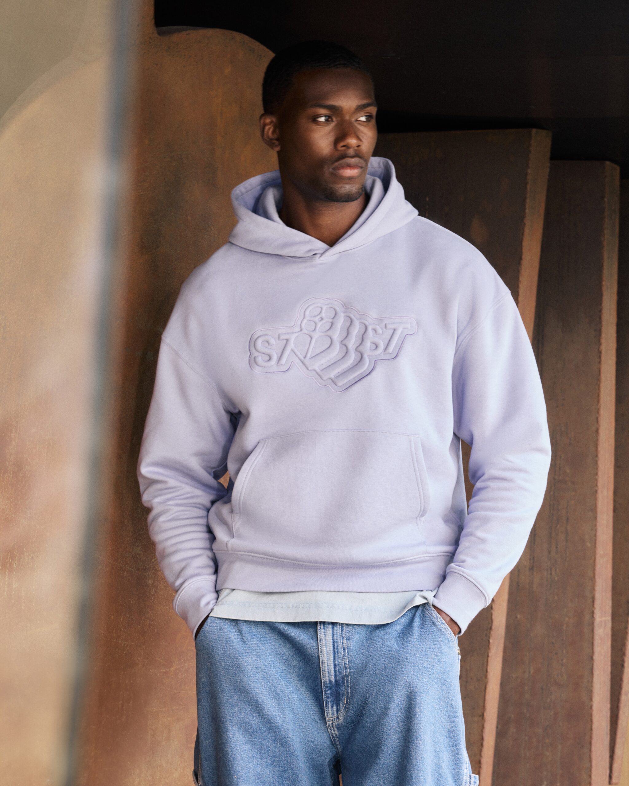 Man posing in light purple lavendar Stanley/Stella hoodie