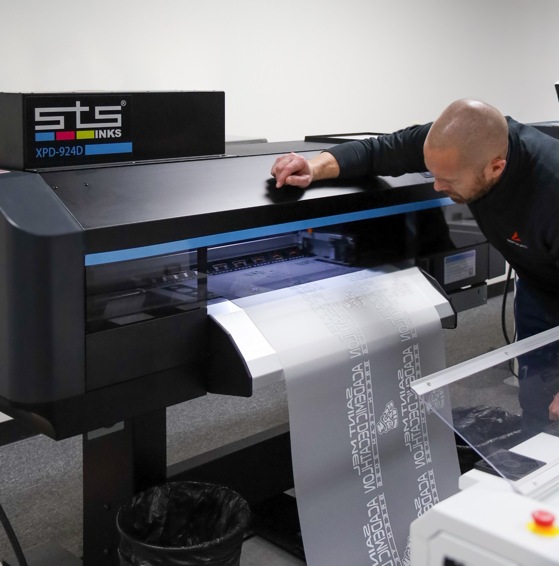man leaning over DTF printing machine